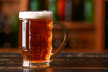 Mug of beer on table in bar.の写真素材