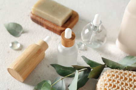 Bottles of cosmetic products, soap and branch on light background, closeupの写真素材