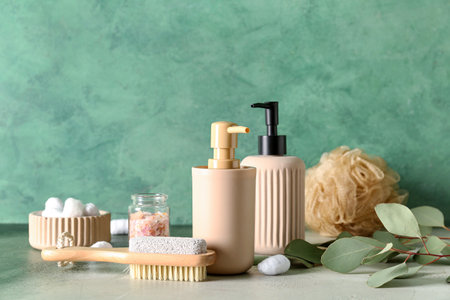 Bottles of cosmetic products, massage brush, sponge, cotton balls and sea salt on color backgroundの写真素材