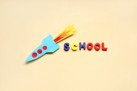 Paper rocket with word SCHOOL on beige backgroundの写真素材