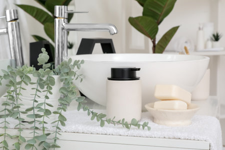 Soap bars, dispenser, houseplant and sink bowl on chest of drawers in bathroomの写真素材