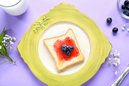 Plate of tasty toast with jam and blueberry on color background, closeupの写真素材