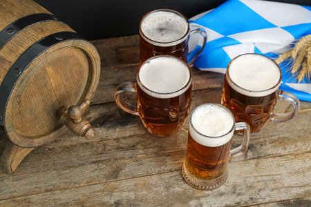 Mugs of cold beer and wooden barrel on table. celebrationの写真素材