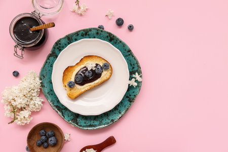 Composition with blueberry jam, toast and flowers on pink backgroundの写真素材