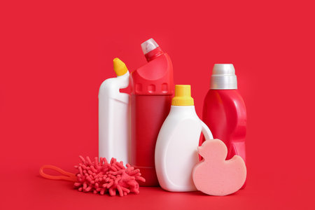 Different cleaning supplies on red backgroundの写真素材