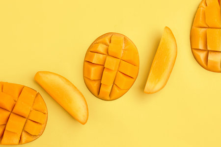 fresh cut mangoes on yellow backgroundの写真素材