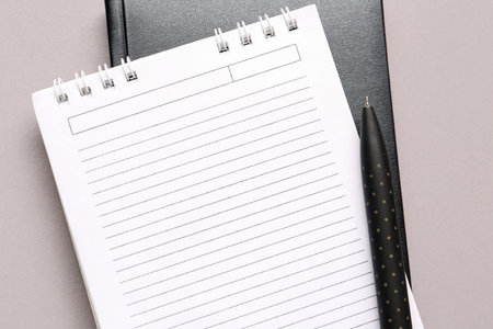 Notebooks and pen on gray background, closeup