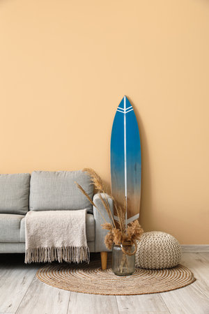 Interior of modern stylish room with surfboard, ottoman and sofaの写真素材