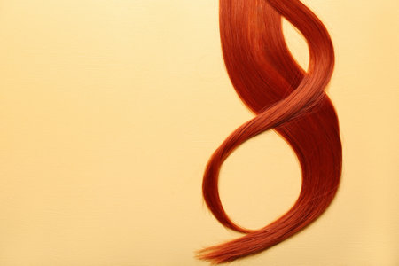 Ginger hair strand on yellow background, closeupの写真素材