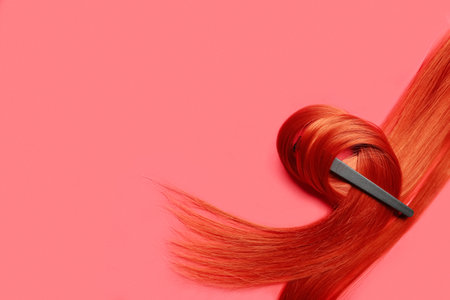 Ginger hair strand with clip on red backgroundの写真素材