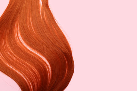 Ginger hair strand on pink background, closeupの写真素材