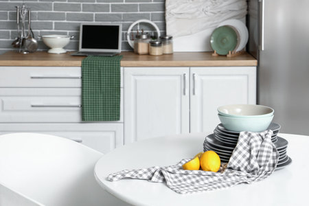 Table with lemons and plates in light kitchen, closeupの写真素材
