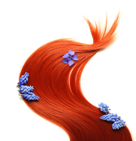 Ginger hair strand with spring flowers on white backgroundの写真素材