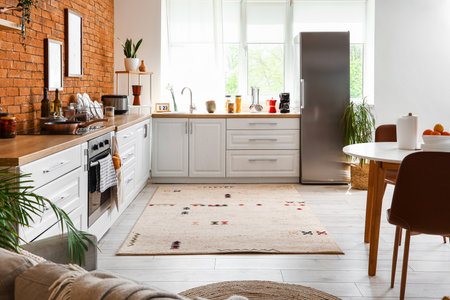 Interior of kitchen with stylish fridge, counters, window and tableの写真素材