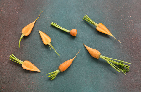 Fresh carrots and halves on dark backgroundの写真素材