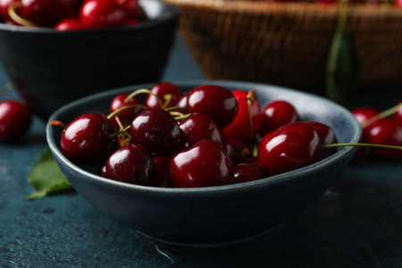 Bowl with sweet cherry on blue backgroundの写真素材