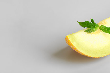 Piece of sweet melon and mint on gray backgroundの写真素材