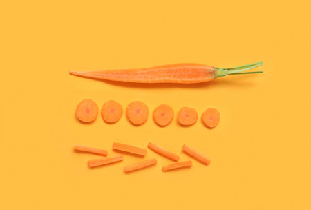 Slices of fresh carrot on orange background