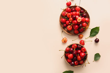 Bowls with sweet cherry on beige backgroundの写真素材