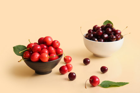Bowls with sweet cherry on beige backgroundの写真素材