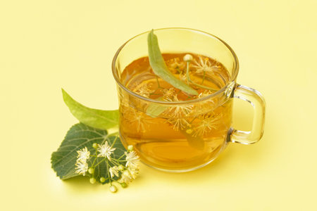 Glass cup of linden tea on yellow backgroundの写真素材