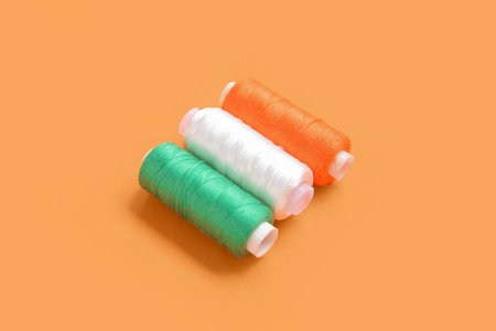 Indian flag made of thread spools on orange background
