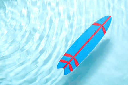 Mini blue surfboard in water