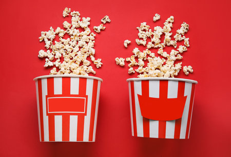 Buckets with tasty popcorn on red backgroundの写真素材