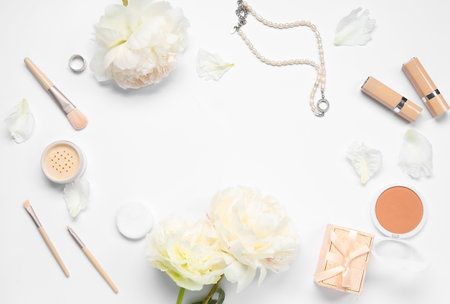 Frame made of female accessories, cosmetics and beautiful peony flowers on white backgroundの写真素材