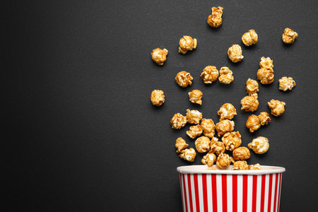 Bucket with tasty popcorn on black backgroundの写真素材