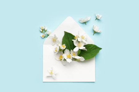 Composition with envelope and beautiful jasmine flowers on color backgroundの写真素材