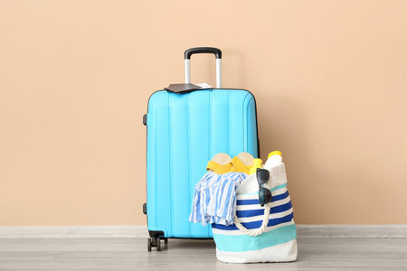 Suitcase with passports, tickets and beach accessories near orange wall. travel conceptの写真素材