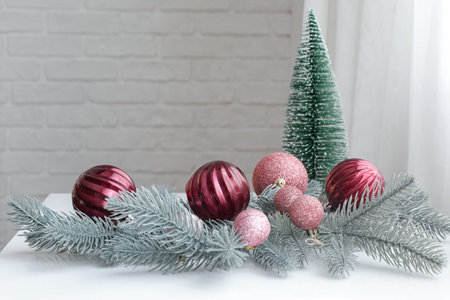 Christmas balls with fir branches and tree on table in room, closeupの写真素材