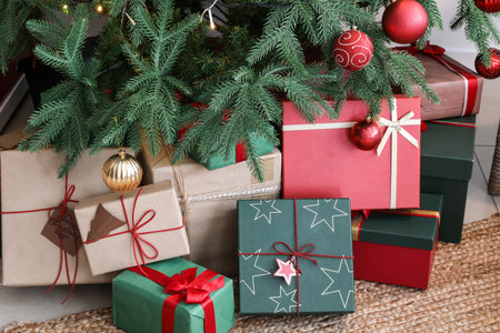 Gift boxes under Christmas tree in living room, closeupの写真素材