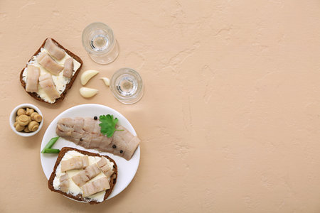 Shots with cold vodka and snacks on beige backgroundの写真素材