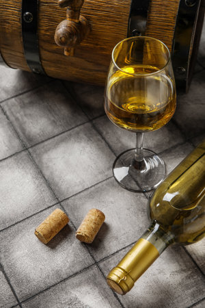 Wooden barrel, bottle and glass of exquisite wine on black tile backgroundの写真素材