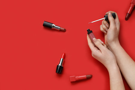 Woman with lipsticks on red backgroundの写真素材