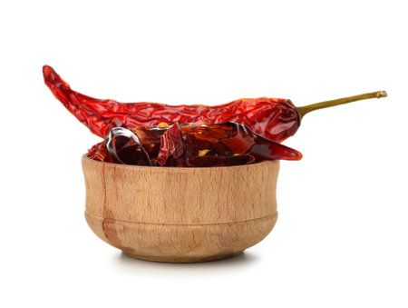 Wooden bowl with sliced chili peppers on white backgroundの写真素材