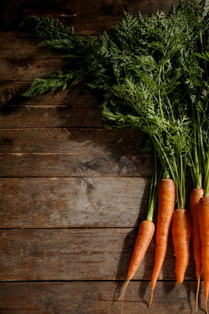 fresh carrots with leaves on wooden backgroundの写真素材