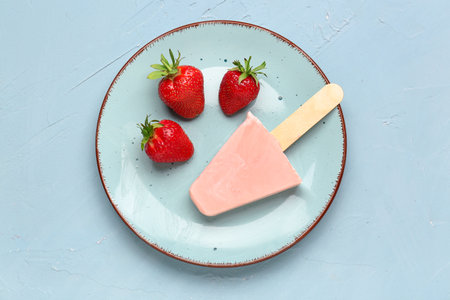 Plate with sweet strawberry ice-cream on blue backgroundの写真素材