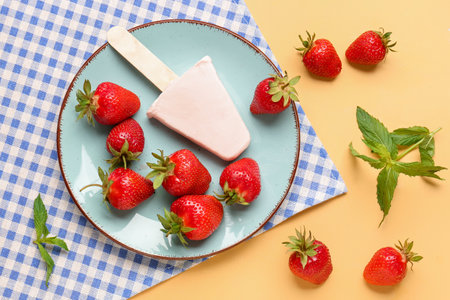 Plate with sweet strawberry ice-cream on yellow backgroundの写真素材