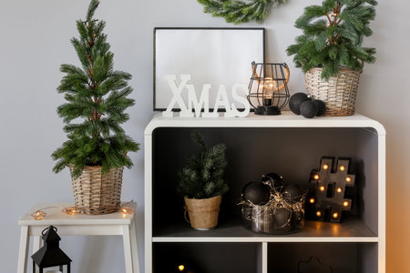 Shelving unit with Christmas trees, glowing lights and decor in roomの写真素材