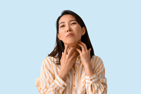Allergic Asian woman scratching on blue backgroundの写真素材