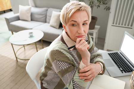 Thoughtful mature woman working at home