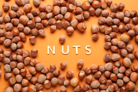 Frame made of shelled hazelnuts on orange backgroundの写真素材