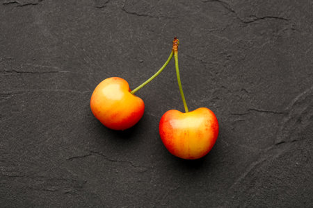 Sweet yellow cherry on black backgroundの写真素材