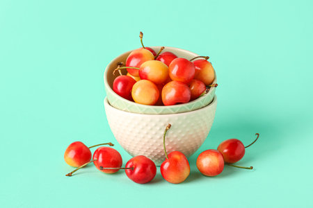 Bowl with sweet yellow cherries on turquoise backgroundの写真素材