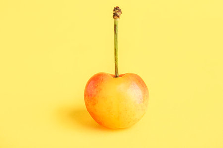 Sweet yellow cherry on color backgroundの写真素材