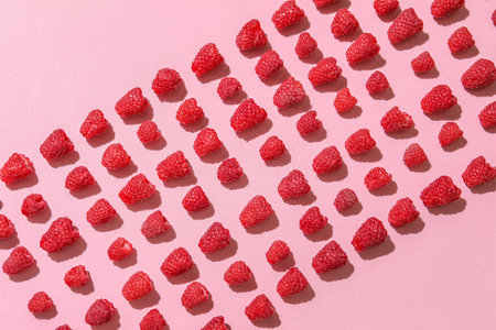 Many fresh raspberries on pink backgroundの写真素材