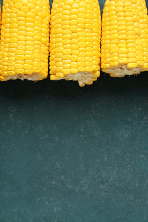Cut fresh corn cobs on green background